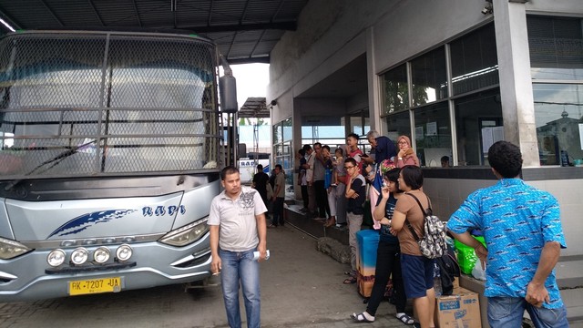 Sejumlah penumpang menunggu kedatangan bus dengan berbagai barang bawaan saat arus balik lebaran. Foto: Rahmat Utomo/kumparan