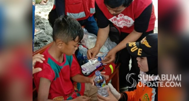 Petugas saat mengobati salah seorang wisatawan yang disengat ubur-ubur di Pantai Citepus Istiqomah, Kecamatan Palabuhanratu, Minggu (9/6/2019). | Sumber Foto:Istimewa.
