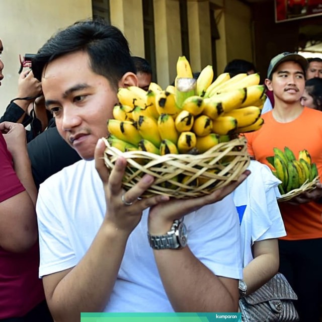 Kedua putra Jokowi, Gibran Rakabuming Raka dan Kaesang Pangarep membawa buah pisang saat berada di Pasar Gede, Solo, Jawa Tengah. Foto: Dok. Muchlis Jr - Biro Pers Sekretariat Presiden