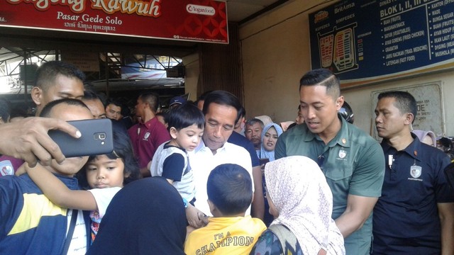 Para pengunjung dan pedagan di Pasar Gede antusias untuk bersalaman dan berfoto bersama Jokowi dan keluarga, Minggu (09/06/2019). (Agung Santoso)