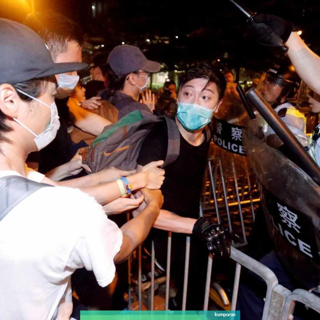 Petugas kepolisian mengamankan sejumlah demonstran, di Hong Kong, Senin (10/6). Foto: REUTERS/Thomas Peter