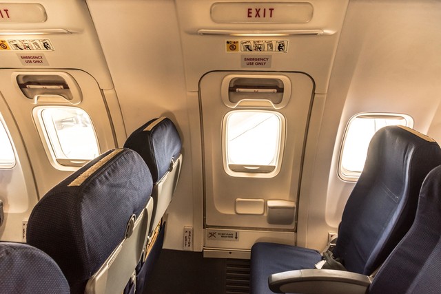 Pintu darurat dalam pesawat atau emergency exit Foto: Shutter Stock