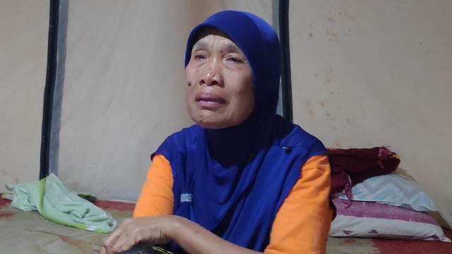 Endang Susilawati, pengungsi korban bencana Palu, menangis saat ditemui wartawan di tenda pengungsiannya di Halaman Masjid Agung, Palu Barat, Kota Palu. Ia teringat keluarganya ketika masih ada yang mengunjunginya. Foto: Ikram/PaluPoso