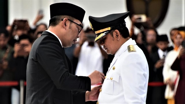 Gubernur Jabar Ridwan Kamil melantik Eka Supria Atmaja (setelan putih) sebagai Bupati Bekasi menggantikan bupati sebelumnya, Neneng Hasanah Yasin, yang kini menjadi terpidana kasus korupsi perizinan proyek Meikarta. (Humas Jabar)  