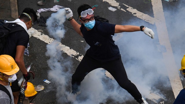 Demonstran melempar selongsong gas air mata. Foto: AFP/ANTHONY WALLACE