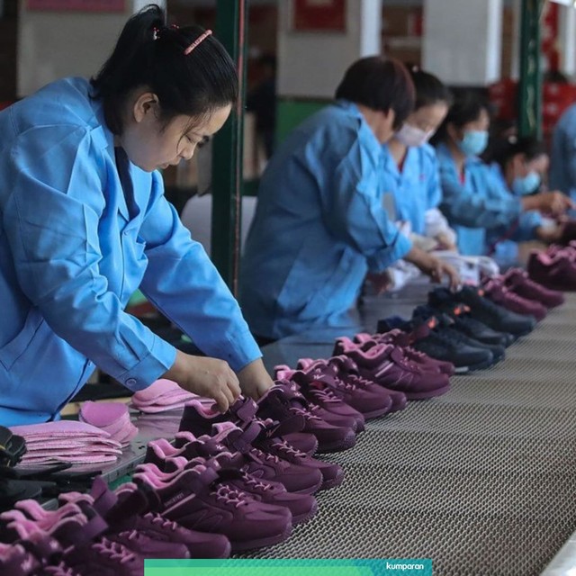 Sejumlah pekerja merapihkan sepatu di China. Foto: AFP