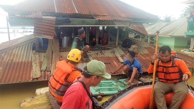 Tim Basarnas mengevakuasi warga di yang terjebak di atas atap rumah akibat banjir yang menghantam Kabupaten Konawe, Foto: Dok Basarnas.