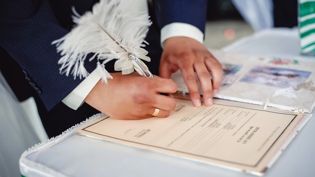 Ilustrasi pengantin pria menanda tangani dokumen pernikahan. Foto: Shutter Stock