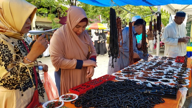 Beberapa pengunjung saat berbelanja pernak pernik yang di jual pedagang di lokasi kegiatan peringatan haul Guru Tua ke-51, di Jalan Sis Aljufri Palu, Sabtu (15/6). Foto: Palu Poso