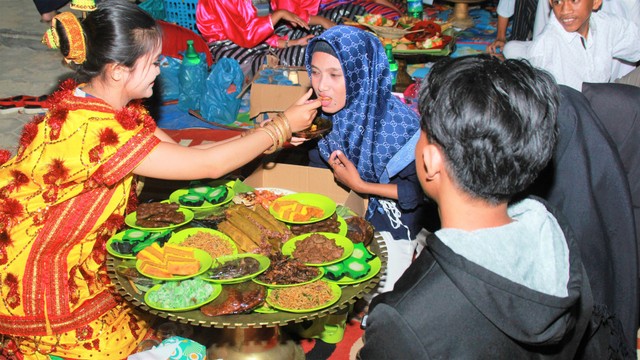 Gadis Buton sedang menyuapi para tamu dengan makanan yang sudah disediakan, Foto: Rusman/kendarinesia.