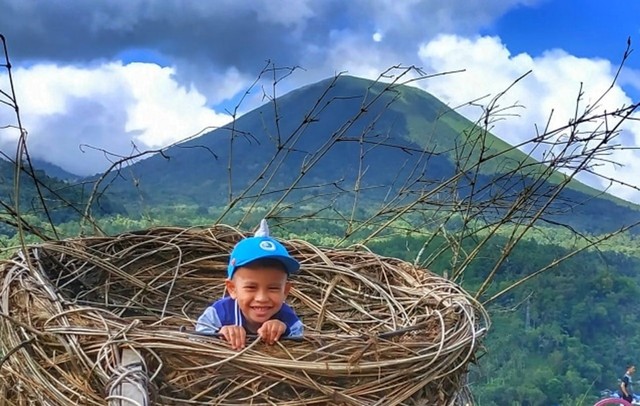 Pengunjung di Taman Valentine Kota Tomohon berfoto di salah spot berlatar pemandangan Gunung Klabat yang disediakan pengelola. Lokasi ini menjadi lokasi alternatif yang recommended untuk para wisatawan (foto: isa anshar jusuf)