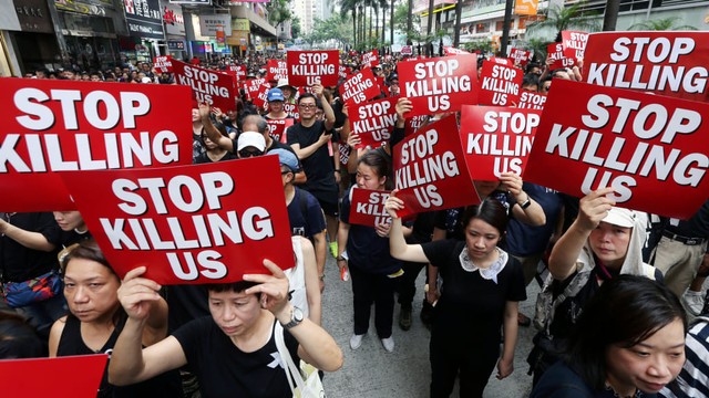 Massa demonstran membawa poster saat menuntut pemimpinnya mundur di Hong Kong, China, Minggu (16/6). Foto: REUTERS/Athit Perawongmetha