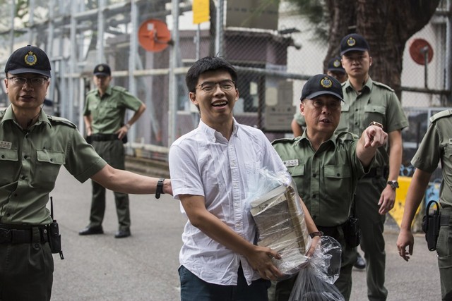 Aktivis demokrasi Hong Kong Joshua Wong (tengah) setelah meninggalkan Lembaga Pemasyarakatan Lai Chi Kok di Hong Kong, Senin (17/6). Foto: ISAAC LAWRENCE / AFP
