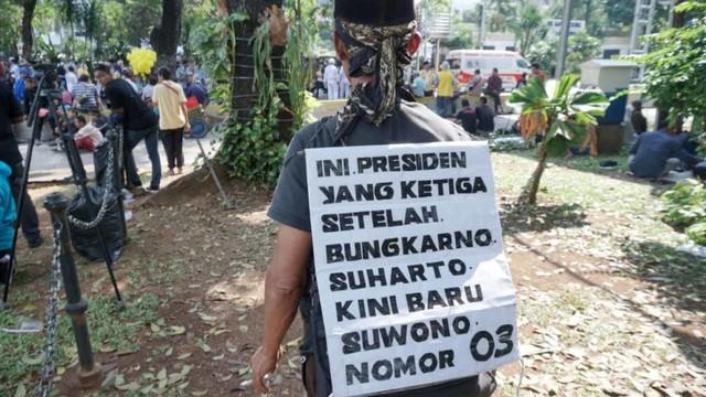 Salah satu massa aksi membawa tanda pada aksi unjuk rasa di kawasan Jalan Medan Merdeka Barat, Jakarta, Selasa (18/6). Foto: Helmi Afandi/kumparan