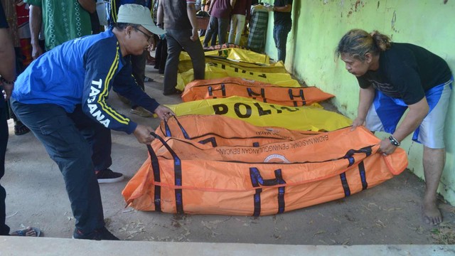 Petugas mengidentifikasi korban meninggal dunia kecelakaan perahu tenggelam di kantor Kecamatan Dungkek, Sumenep, Jawa Timur, Selasa (18/6/2019). Foto: ANTARA FOTO/Saiful Bahri
