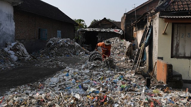 Warga memilah tumpukan sampah plastik impor di halaman rumahnya di Desa Bangun di Mojokerto, Jawa Timur, Rabu (19/6). Foto: ANTARA FOTO/Zabur Karuru