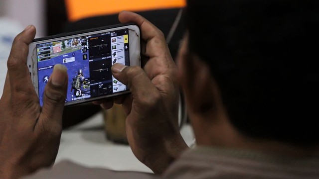 Warga bermain game Player Unknown's Battle Grounds (PUBG) melalui telepon pintar. Foto: ANTARA FOTO/Rahmad