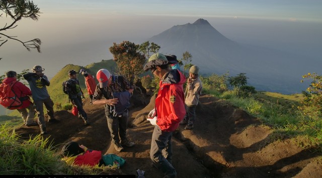 Para pendaki saat menuju puncak Gunung Merbabu dengan latar belakang Gunung Merapi. Foto: Tim Jelajah 54 TN Indonesia