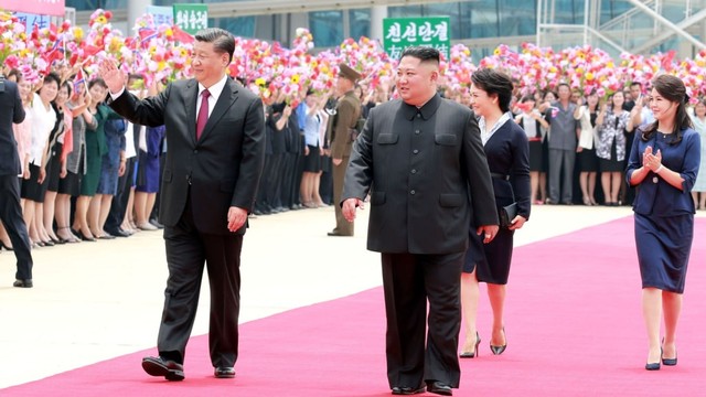Pemimpin Korea Utara Kim Jong Un (kedua kanan)  dan Presiden China Xi Jinping (kiri) menyapa warga selama pertemuan di Pyongyang, Korea Utara. Foto: Reuters/KCNA