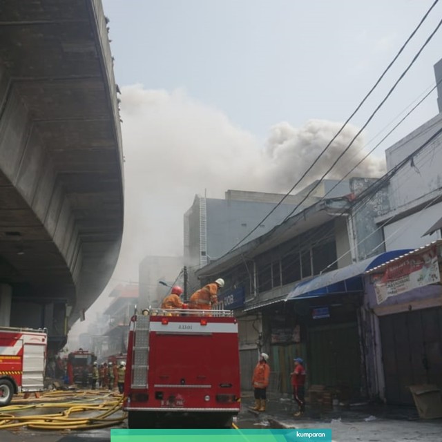 Petugas pemadam kebakaran berusaha memadamkan api yang membakar gudang petasan di Jalan Asemka, Jakarta Barat, Jumat (21/6). Foto: Nugroho Sejati/kumparan