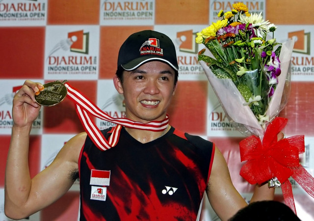 Taufik Hidayat menunjukkan mendali emasnya usai menjuarai bulutangkis tunggal putra Indonesia Open Badminton Championship. Foto: AFP/JEWEL SAMAD