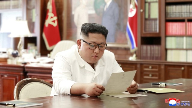 Kim Jong-un membaca surat dari Donald Trump Foto: Reuters/KCNA