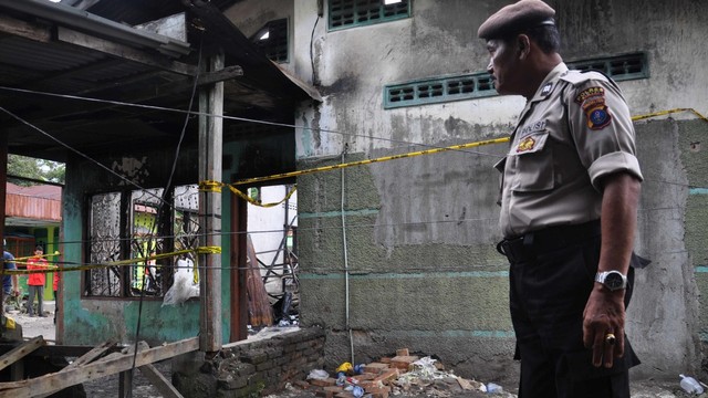 Polisi menjaga lokasi rumah yang dijadikan pabrik pembuat korek gas (mancis) pasca kebakaran di Desa Sambirejo, Kecamatan Binjai, Kabupaten Langkat, Sumatera Utara, Sabtu (22/6). Foto: ANTARA FOTO/Septianda Perdana