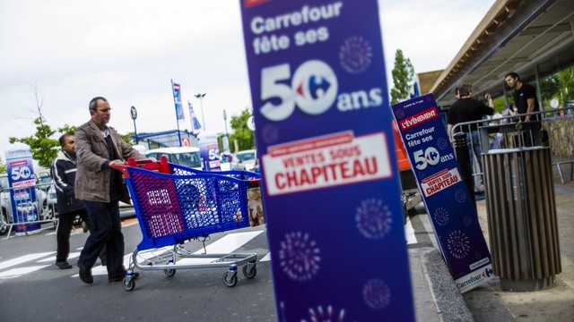 Seorang pelanggan mendorong kereta belanja ketika ia tiba di supermarket Carrefour di Paris. Foto: Fred Dufour / AFP
