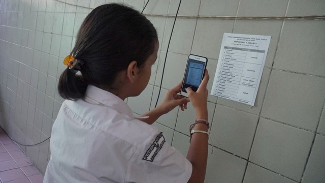 Peserta memotret data zonasi PPDB di SMP Negeri 1 Jakarta, Senin (24/6). Foto: Helmi Afandi Abdullah/kumparan