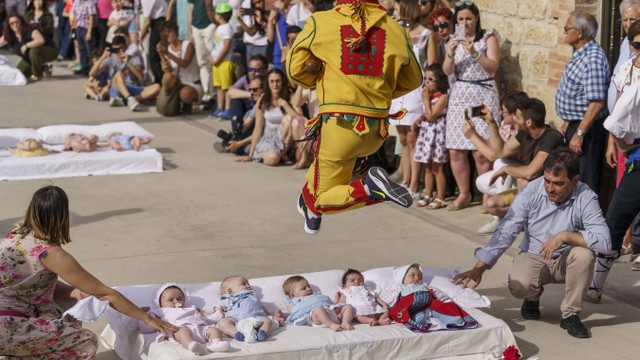 Colacho, karakter yang mewakili iblis, melompati bayi pada festival 'El Colacho' di desa Castrillo de Murcia, Spanyol, Minggu (23/6). Foto: AFP/CESAR MANSO