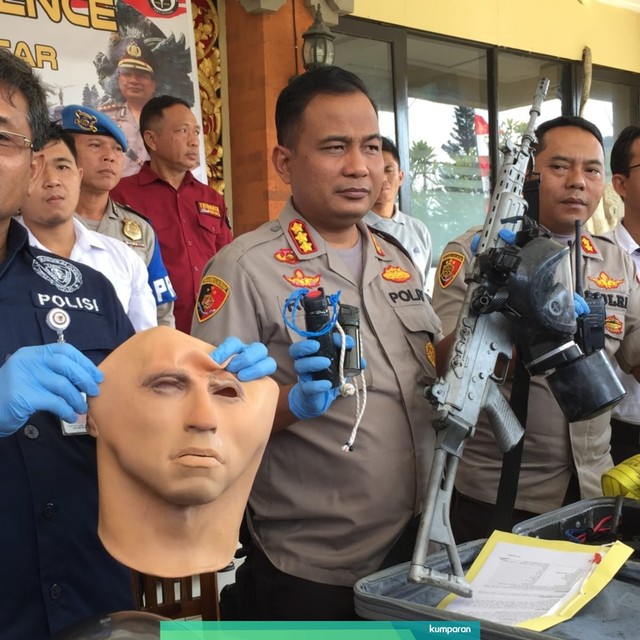 Anggota kepolisian Polresta Denpasar menunjukkan barang bukti senjata yang ditemukan di dalam bagasi mobil. Foto: Denita BR Matondang/kumparan