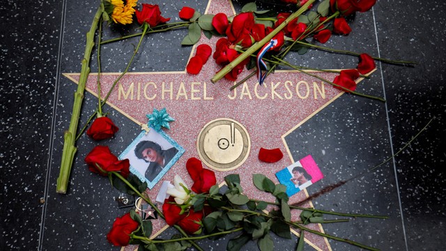 Bunga dan foto mengelilingi bintang Michael Jackson di Hollywood Walk of Fame saat peringatan satu dekade kematiannya di Los Angeles, California, AS, Selasa (25/6). Foto: REUTERS/Mike Blake
