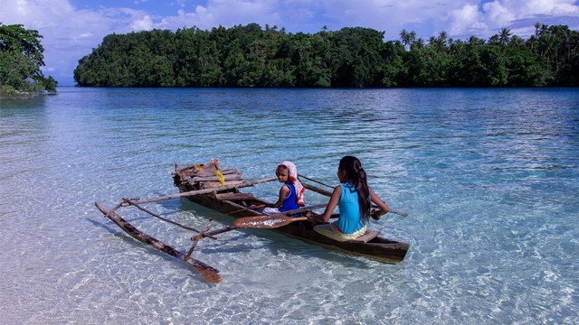 Anak-anak perempuan di Pulau Meti mencari kayu bakar menggunakan sampan. Foto: Ipang Mahardhika/cermat