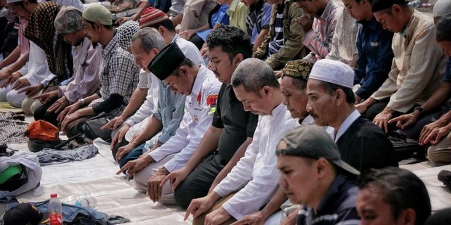 Massa aksi melaksanakan salat berjamaah di kawasan Patung Kuda, Jakarta Pusat, Kamis (27/6). Foto: Jamal Ramadhan/kumparan
