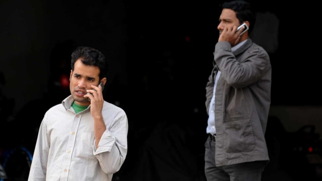 Ilustrasi warga Bangladesh bermain telepon genggam. Foto: AFP