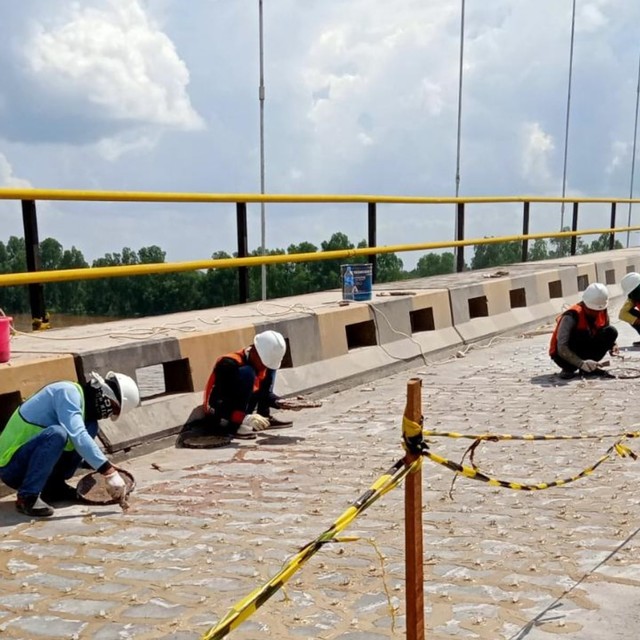 Pekerja memperbaiki lantai Jembatan Barito yang terletak di Kecamatan Anjir Muara, Kabupaten Barito Kuala, Kalimantan Selatan, Kamis 27 Juni 2019. Foto: Donny Muslim/banjarhits.id