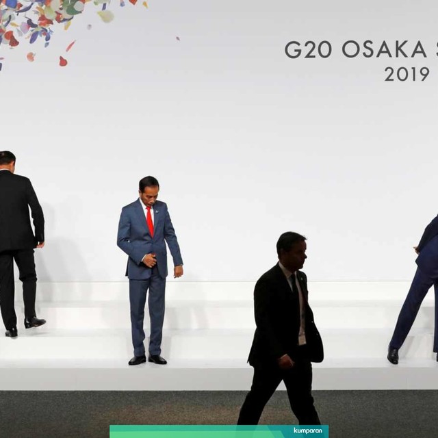 Perdana Menteri Jepang Shinzo Abe (kanan) dan Presiden Indonesia Joko Widodo (tengah) saat memeriksa posisi mereka jelang foto bersama dengan pemimpin negara G20, Osaka, Jepang (28/6) Foto: Reuters