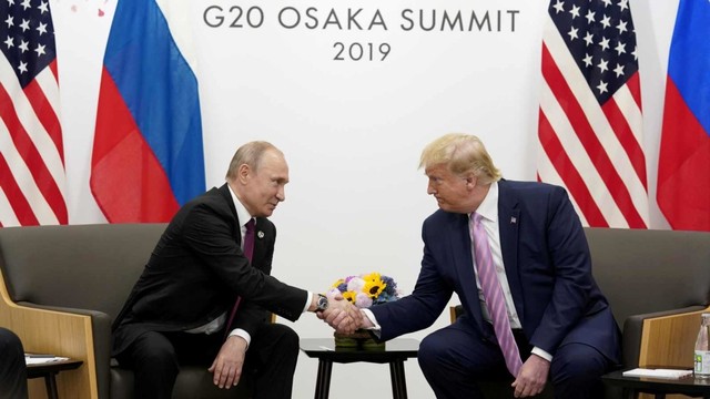 Presiden Vladimir Putin dan Presiden Donald Trump bersalaman. Foto: Reuters