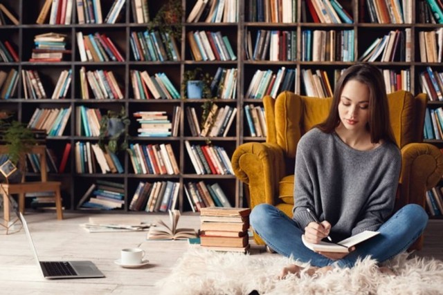 perempuan kerja dari rumah menulis di buku