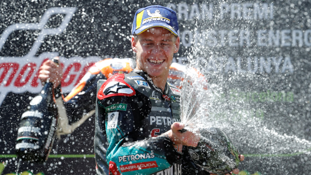 Pebalap Petronas Yamaha, Fabio Quartararo, merayakan kesuksesan menaiki podium di GP Catalunya. Foto: Pau Barrena/AFP