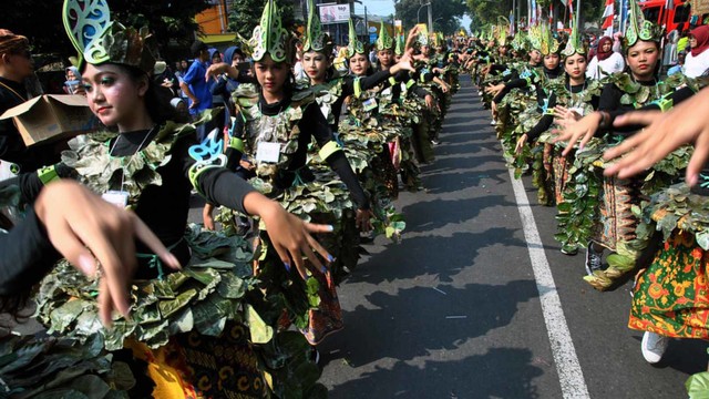 Peserta mengenakan kostum pada Helaran Seni Budaya di jalan Sudirman, Kota Bogor, Jawa Barat, Minggu (30/6). Foto: ANTARA FOTO/Arif Firmansyah