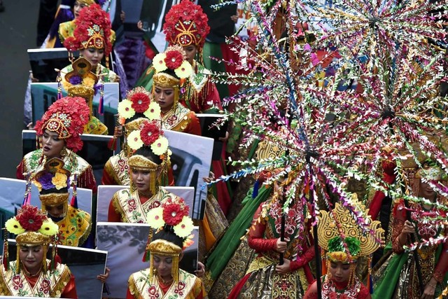 Peserta mengenakan busana daerah pada festival budaya Jakarnaval 2019 di Jalan MH Thamrin, Jakarta, Minggu (30/6). Foto: ANTARA FOTO/Galih Pradipta