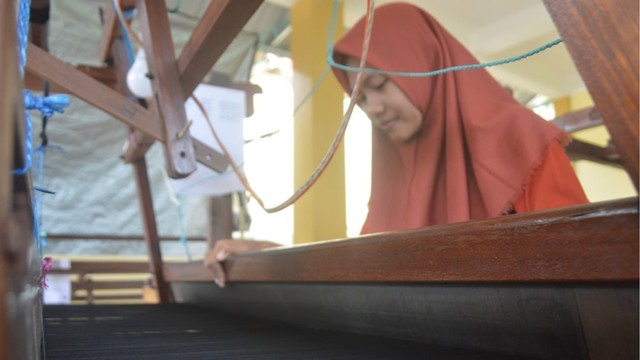 Salah seorang penenun sibuk menyelesaikan kain tenun pesanan konsumen. Foto: Olis/cermat
