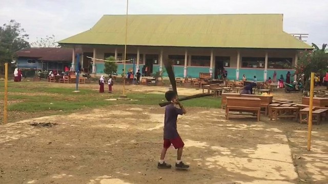 Bangku sekolah di SD Negeri 1 Praja Taman Sari, Kabupaten Konawe, dijejer di luar kelas untuk dijemur, Foto: Tangkapan layar video.