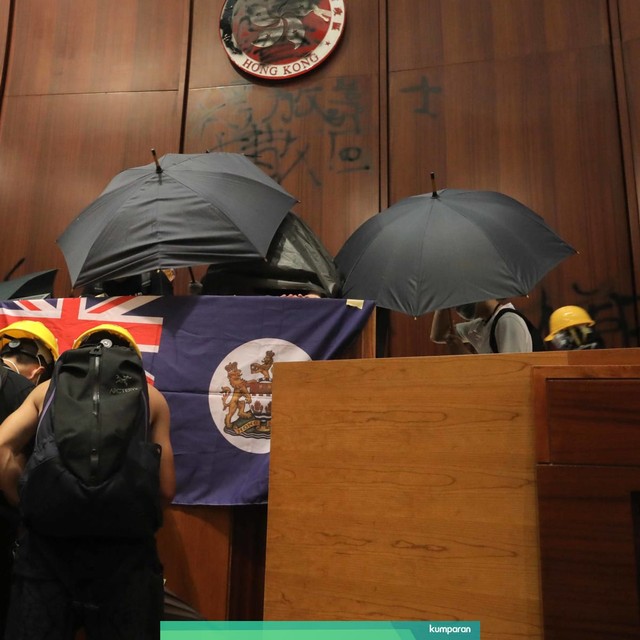 Pengunjuk rasa memasang bendera British Hong Kong di gedung parlemen Hong Kong. Foto: AFP/Viviek Prakash