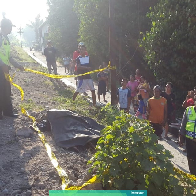 Warga dan Kepolisian Berbah mengelilingi korban tewas akibat terambar Kereta Api di Berbah, Kabupaten Sleman, DI Yogyakarta. Foto: dok. Istimewa