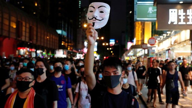 Salah seorang demonstran membawa topeng saat melakukan demo menolak Undang-undang Ekstradisi di Nathan Road dekat Mongkok, Hong Kong, China (7/7). Foto: REUTERS/Tyrone Siu