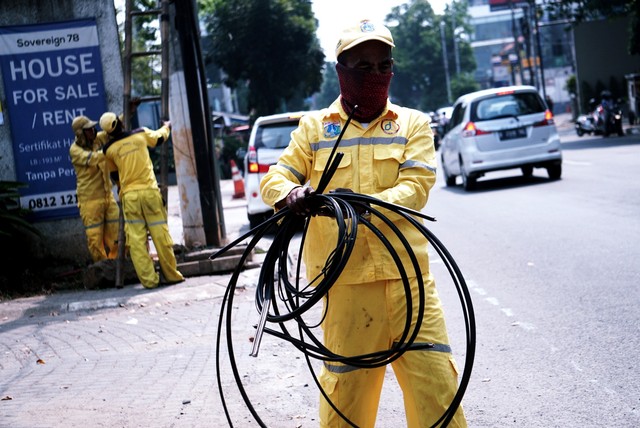 Petugas menertibkan kabel utilitas di Jalan Kemang Raya, Jakarta Selatan, Senin (8/7/2019). Foto: Iqbal Firdaus/kumparan