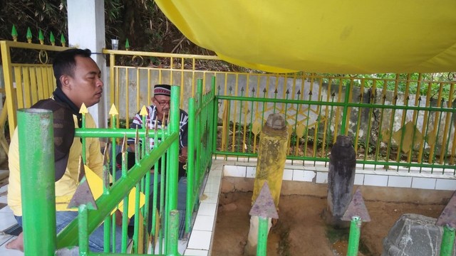 Dua peziarah terlihat sedang memanjatkan doa di salah satu makam yang berada di puncak gunung Pulau Lutungan, Kelurahan Nalu, Kecamatan Baolan, Kabupaten Tolitoli, Sulawesi Tengah. Foto: Mohamad Sabran/PaluPoso