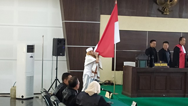 Habib Bahar saat ciium Bendera Merah Putih di Kantor Dinas Perpusatakaan dan Kearsipan, Kota Bandung, Selasa (9/7). Foto: Rachmadi Rasyad/kumparan